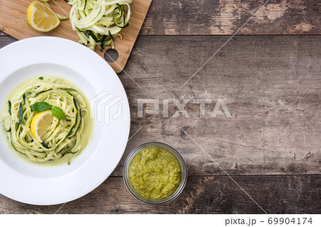 Zucchini noodles with pesto sauce on wooden table Zucchini noodles with pesto sauce on wooden table 69904174