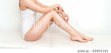 Woman cuts hair on her legs by scissors Woman cuts hair on her legs by scissors 69904182