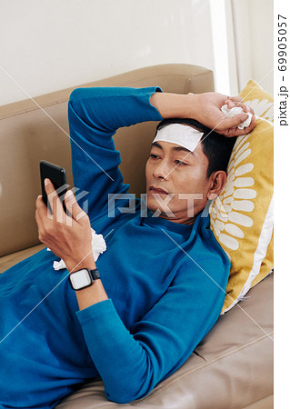 Sick man reading article online 69905057
