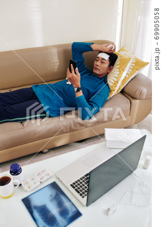 Sick man resting on sofa 69905058