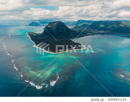 Tropical island with Le Morne mountain, ocean and underwater waterfall in Mauritius. Aerial view Tropical island with Le Morne mountain, ocean and underwater waterfall in Mauritius. Aerial view 69905133