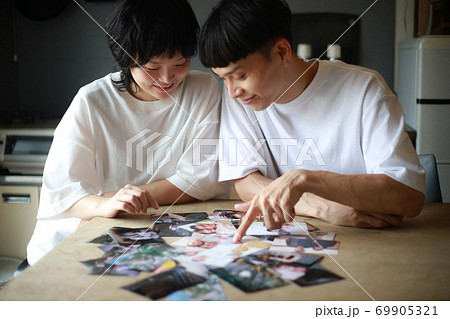 写真を見るカップル 69905321