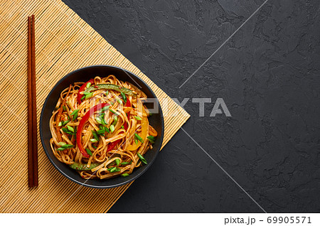 Vegetarian Schezwan Noodles or Vegetable Hakka Noodles or Chow Mein in black bowl on slate table .  69905571