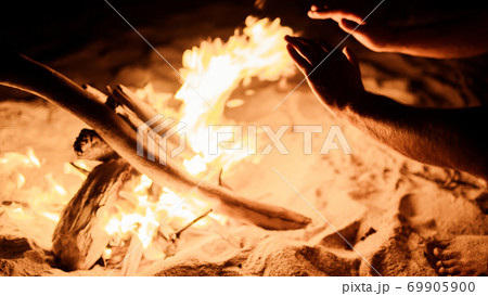 hands by the fire on the beach hands by the fire on the beach 69905900
