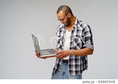 A young african american man working with a laptop pc 69905948