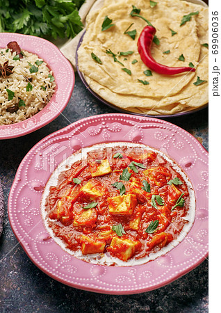 Paneer Makhani, Jeera Rice and paratha in pink plate on dark background. Paneer Makhani, Jeera Rice and paratha in pink plate on dark background. 69906036