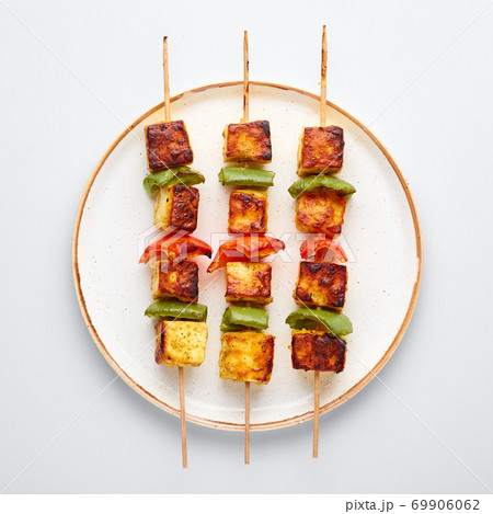 Paneer Tikka at skewers in white plate isolated at white background. Paneer tikka is an indian cuisine dish. Indian Food Paneer Tikka at skewers in white plate isolated at white background. Paneer tikka is an indian cuisine dish. Indian Food 69906062