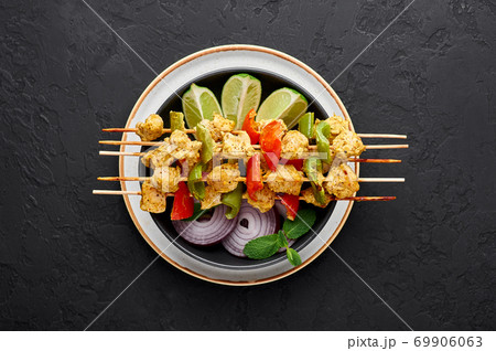 Chicken Tikka at skewers in black bowl on dark slate table top. Indian cuisine dish. Indian food Chicken Tikka at skewers in black bowl on dark slate table top. Indian cuisine dish. Indian food 69906063
