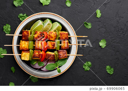Chicken Tikka at skewers in black bowl on dark slate table top. Indian cuisine dish. Indian food Chicken Tikka at skewers in black bowl on dark slate table top. Indian cuisine dish. Indian food 69906065