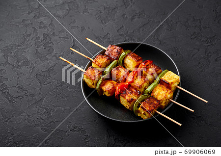 Chicken Tikka at skewers in black bowl on dark slate table top. Indian cuisine dish. Indian food Chicken Tikka at skewers in black bowl on dark slate table top. Indian cuisine dish. Indian food 69906069