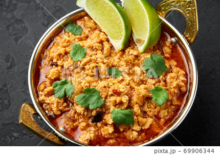 Chicken keema in traditional indian copper kadai at dark slate background. Chicken keema in traditional indian copper kadai at dark slate background. 69906344
