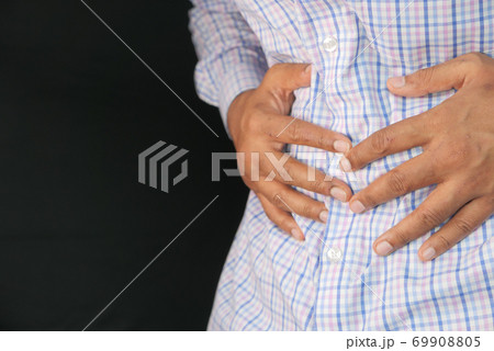 young man suffering stomach pain close up. young man suffering stomach pain close up. 69908805