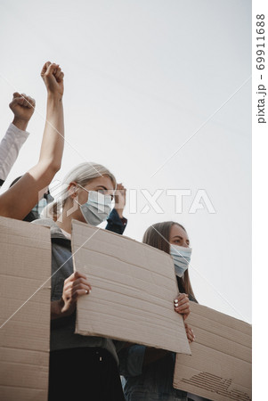 Group of activists giving slogans in a rally. Men and women marching together in a protest in the city. Group of activists giving slogans in a rally. Men and women marching together in a protest in the city. 69911688