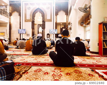 KUALA LUMPUR, MALAYSIA -AUGUST 14, 2020: The atmosphere in the mosque that practices social distancing while performing prayers during the Covid-19 pandemic. Muslim men are performing Friday prayers. KUALA LUMPUR, MALAYSIA -AUGUST 14, 2020: The atmosphere in the mosque that practices social distancing while performing prayers during the Covid-19 pandemic. Muslim men are performing Friday prayers. 69912840