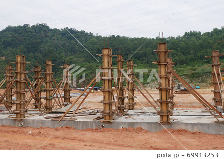 KUALA LUMPUR, MALAYSIA -SEPTEMBER 19, 2020: Column timber formwork and reinforcement bar at the construction site. Installed by construction workers. The structure supported by temporary wood support. 69913253