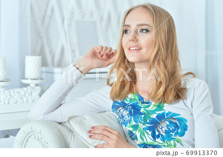Portrait of beautiful young woman daydreaming at home Portrait of beautiful young woman daydreaming at home 69913370