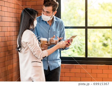 Two Busineepersons discuss brainstorm with face mask. 69915367