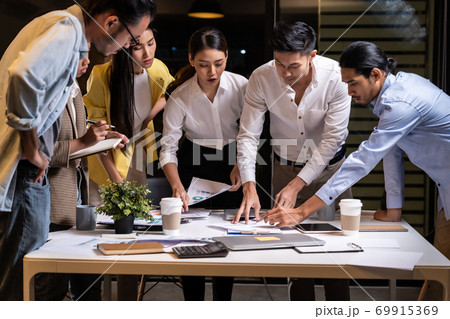 Working late, interracial asian business team brainstorm idea meeting. 69915369