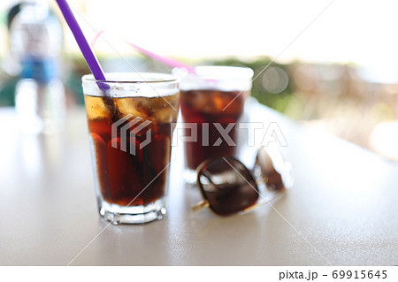 Table two dark colored cocktails with straw Table two dark colored cocktails with straw 69915645