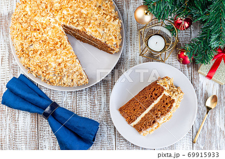 Piece of Carrot cake with cream cheese frosting and walnuts, Christmas decoration on a background, horizontal, top view Piece of Carrot cake with cream cheese frosting and walnuts, Christmas decoration on a background, horizontal, top view 69915933