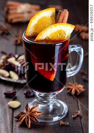 Red glogg or mulled wine with orange slices and cinnamon stick on dark wooden background, vertical, closeup Red glogg or mulled wine with orange slices and cinnamon stick on dark wooden background, vertical, closeup 69916057