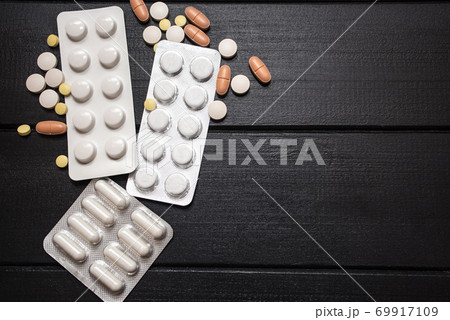 Medical Tools, Syringe and Colorful Drugs and Capsules Medicine Concept, Brown Wood Background 69917109