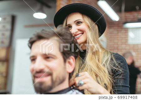 Man consulting woman hair stylist for advise on cut and styling 69917408