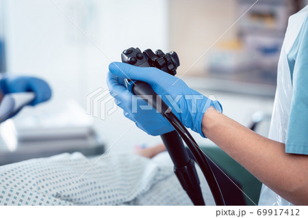 Doctor holding endoscope during colonoscopy 69917412
