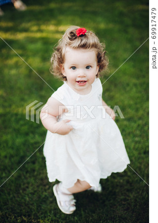 Smiling little girl in white evening summer dress 69917479