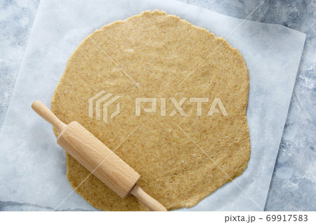 Rolled out pie or cookies dought on baking paper. Top view. 69917583
