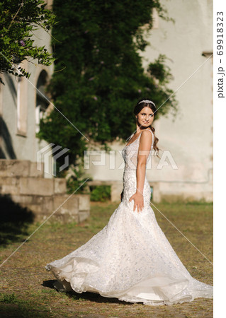 Young female model in wedding dress outdoors. Fashion photo of bride 69918323