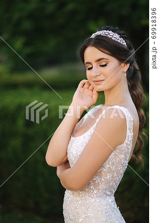 Portrait of young bride in white wedding dress outdoors. Fashion makeup Portrait of young bride in white wedding dress outdoors. Fashion makeup 69918396