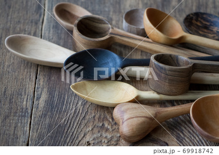 Side view lot of wooden spoons made of precious wood on wooden table, eco-friendly concept of cutlery, handmade tableware production 69918742