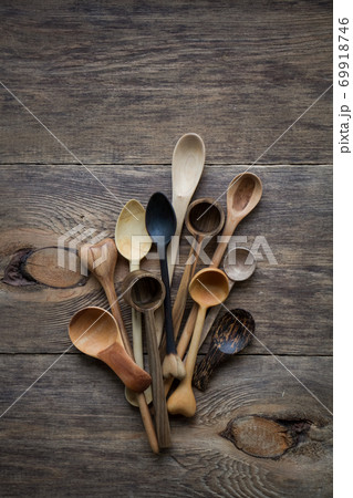 Top view lot of wooden spoons made of precious wood on wooden table, eco-friendly concept of cutlery, handmade tableware production Top view lot of wooden spoons made of precious wood on wooden table, eco-friendly concept of cutlery, handmade tableware production 69918746