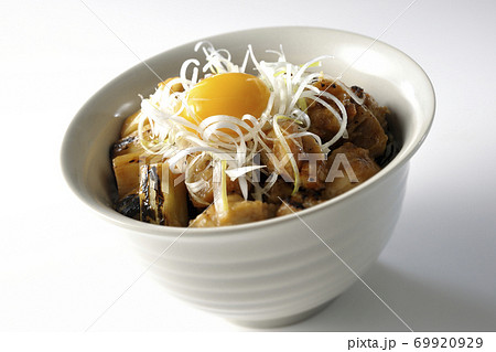 炭火で焼いた焼き鳥の上に白髪葱と卵黄を乗せた丼ぶり（白背景） 69920929