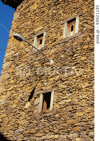 Facade with windows and lamp looking like a face 69921185
