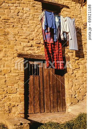Old house with wooden door and hanging clothes 69921186