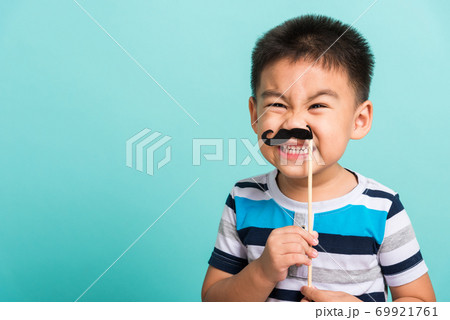 Funny happy hipster kid holding black mustache 69921761