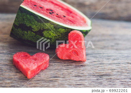 Healthy watermelon smoothie with mint, a piece of watermelon, hearts and a striped straw on a wood background 69922201