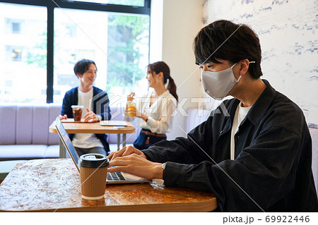 カフェでパソコンを開く男性　カフェでくつろぐ男女　 69922446