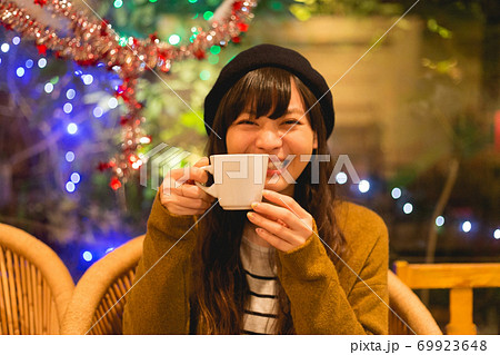 カフェでコーヒーを飲むニットの上着を着た女性 69923648