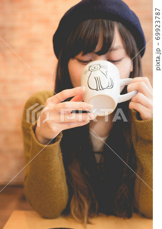 カフェでコーヒーを飲むニットの上着を着た女性 カフェでコーヒーを飲むニットの上着を着た女性 69923787