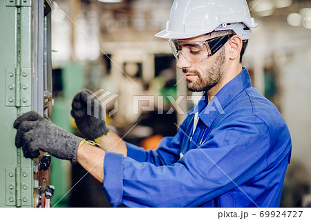 Hispanic latin labor worker hard working with safety glasses and helmet in factory 69924727
