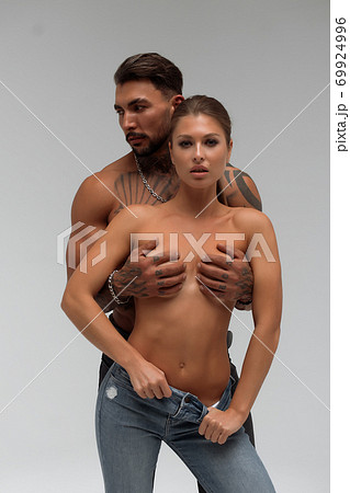 Muscular man hugging topless woman 69924996