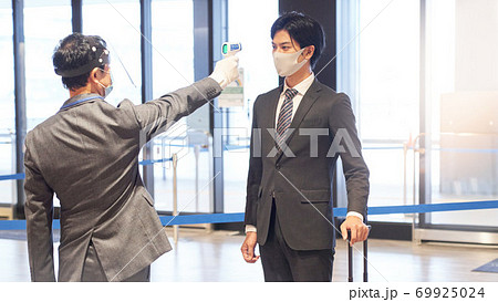 非接触温度計で体温測定を受ける男性 非接触温度計で体温測定を受ける男性 69925024