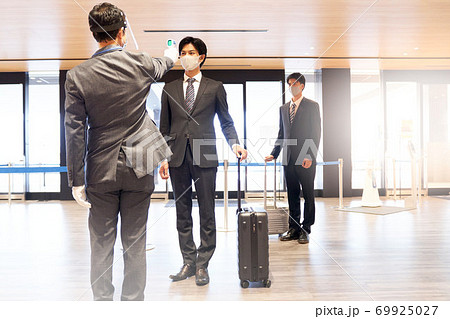 非接触温度計で体温測定を受ける男性（全身） 69925027