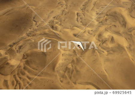 A microlight aircraft can be seen flying over the sands of Namibia A microlight aircraft can be seen flying over the sands of Namibia 69925645