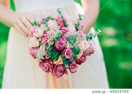 Wedding bouquet of white and red roses in bride's hands 69929769