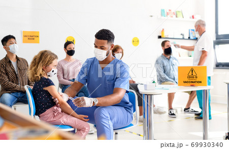 Child with face mask getting vaccinated, coronavirus, covid-19 and vaccination concept. 69930340