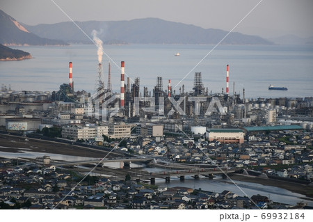 広島県大竹市の大河原山から見た山口県和木町のENEOS麻里布製油所や鉄橋を渡る電車を中心とした風景 69932184